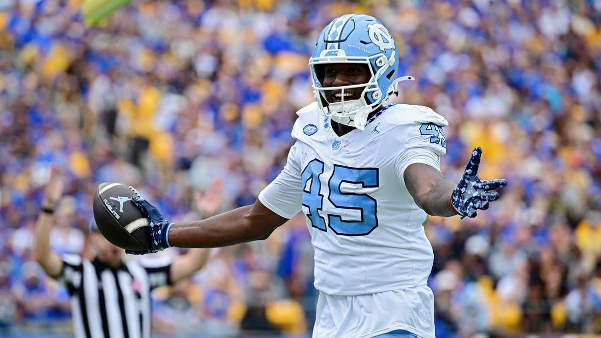 Jelani Thurman celebrates after a touchdown reception during a college football game.
