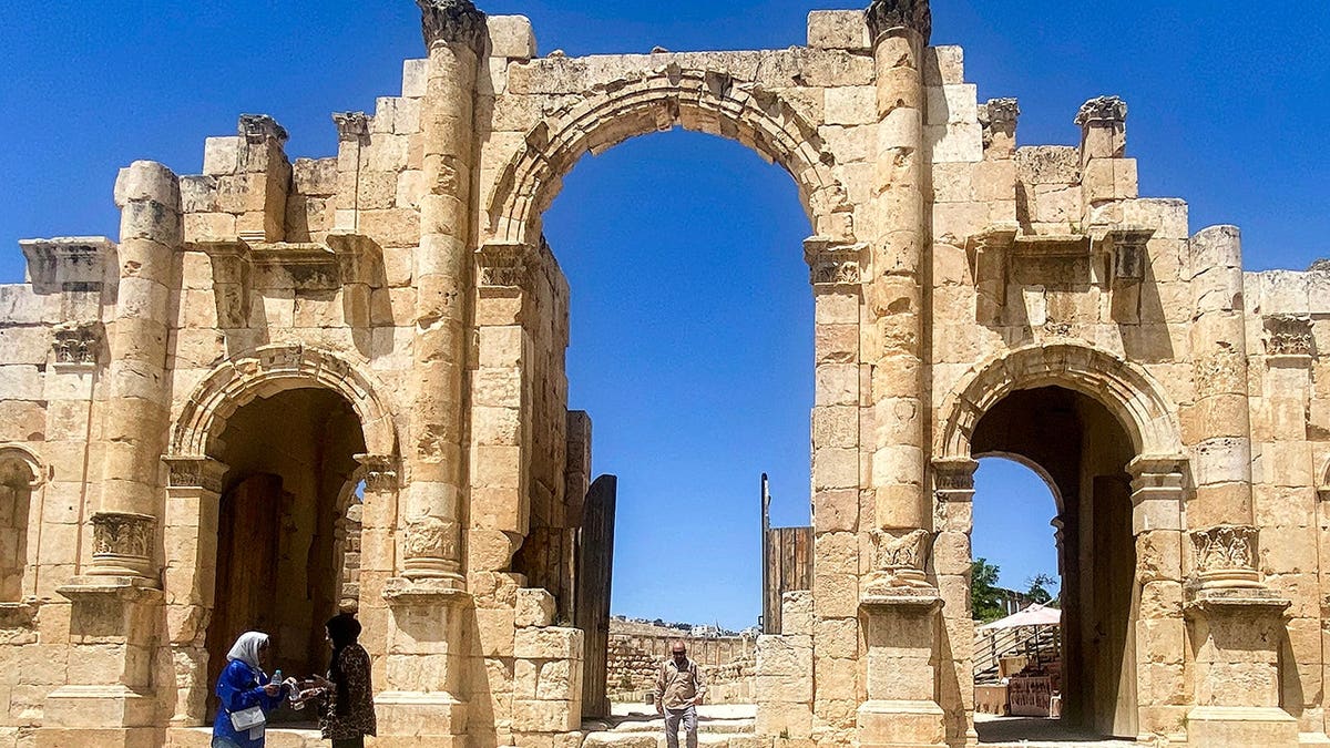 People stand before the Roman-era South Gate at Jerash ruins in northern Jordan.