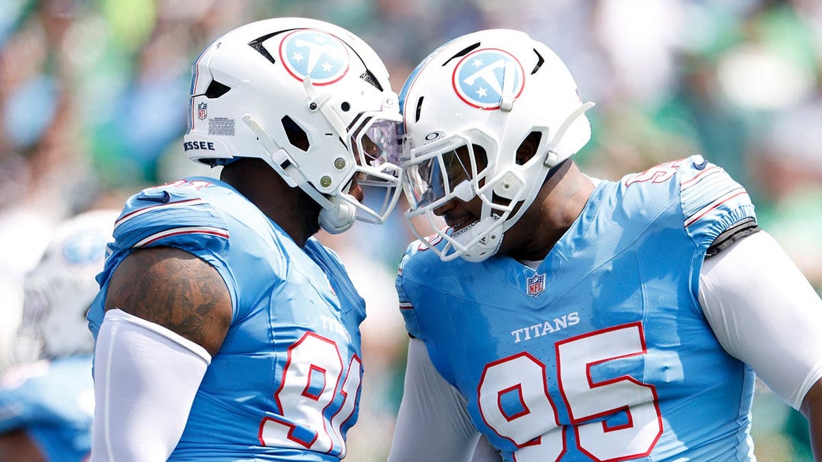 John Franklin-Myers and Jordan Elliott of the Tennessee Titans celebrate after a tackle.