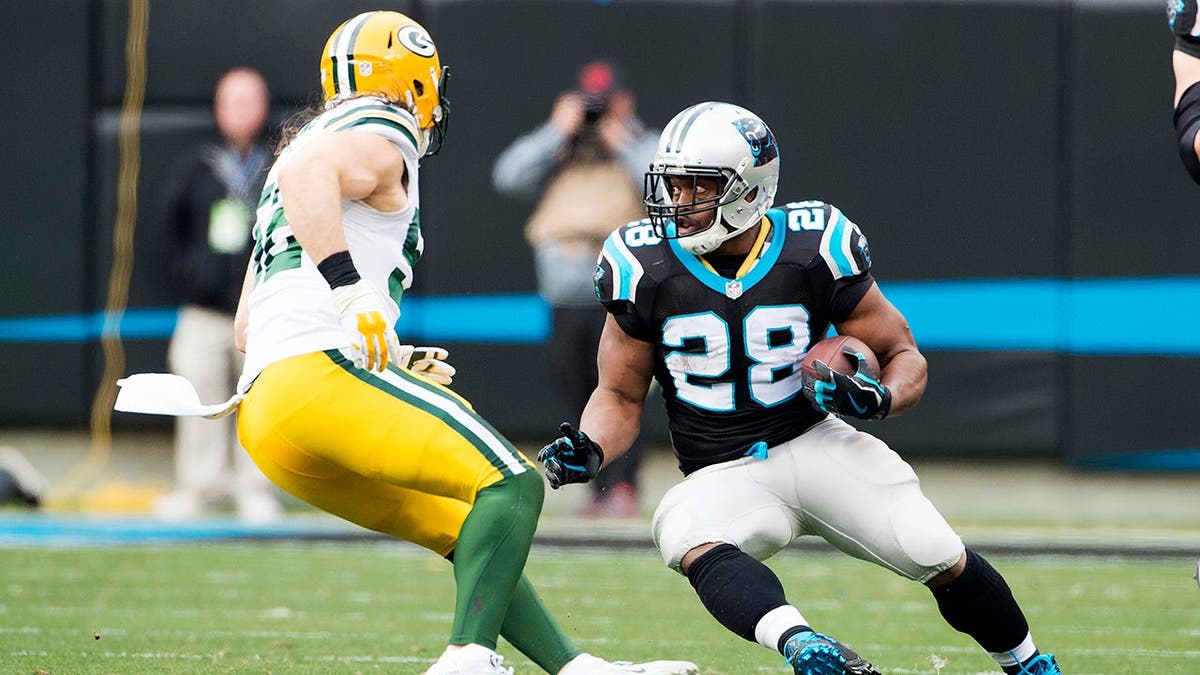 Jonathan Stewart carries the ball during an NFL game against the Green Bay Packers.