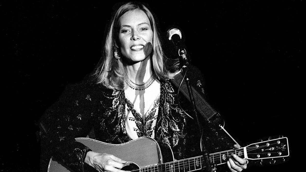 Joni Mitchell performs with a guitar onstage at The Boston Music Hall.