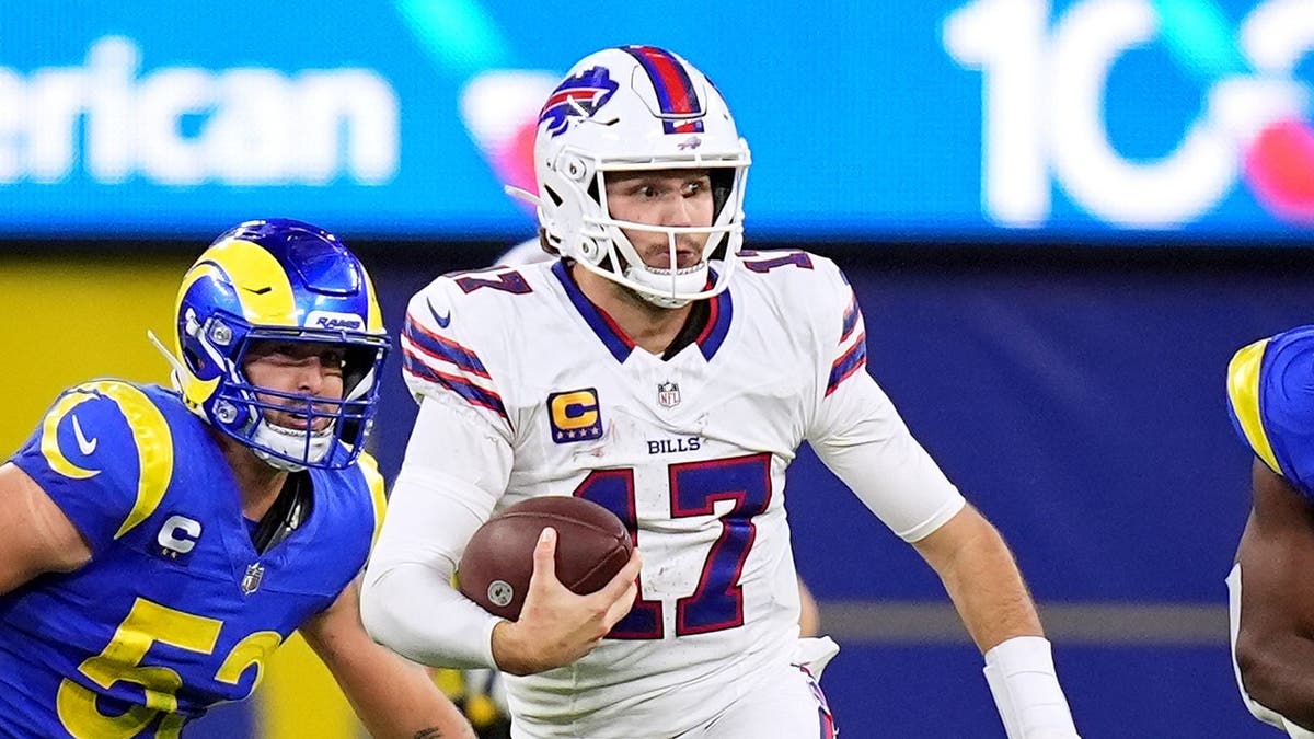 Josh Allen runs with the ball while Nate Landman and Josaiah Stewart chase during an NFL game.