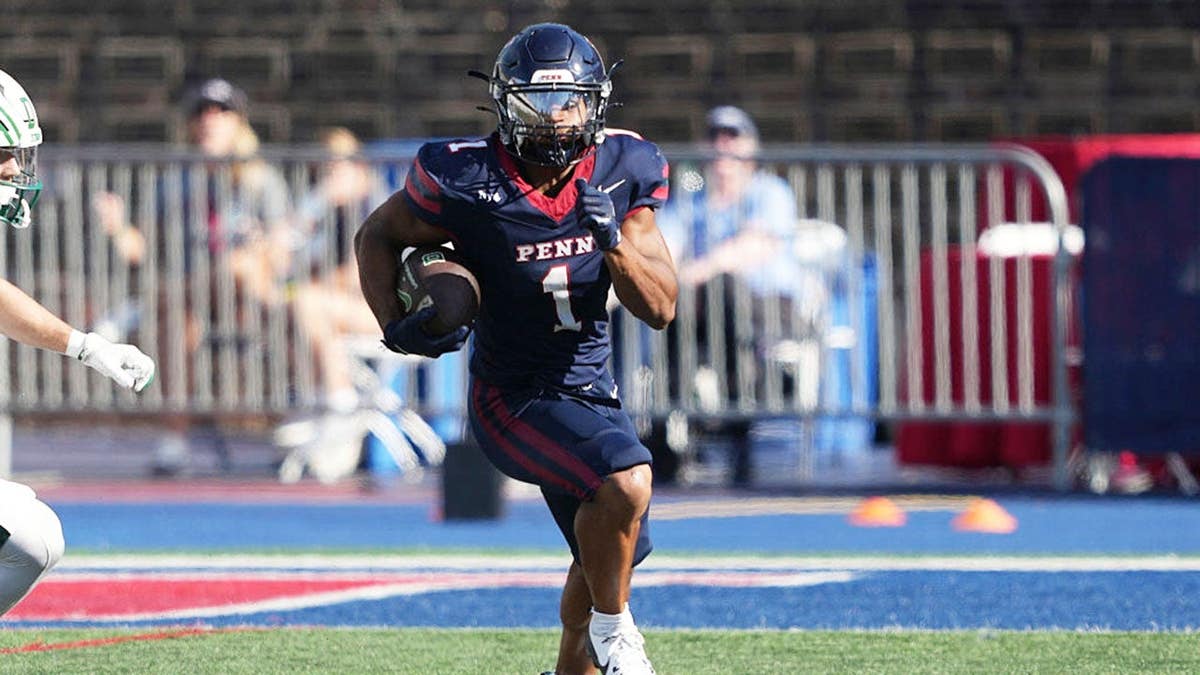 Julien Stokes runs with the ball during a Penn Quakers game at Franklin Field.