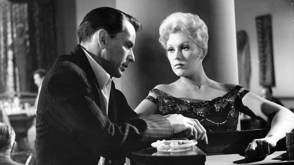 Kim Novak looking at Frank Sinatra in a scene.
