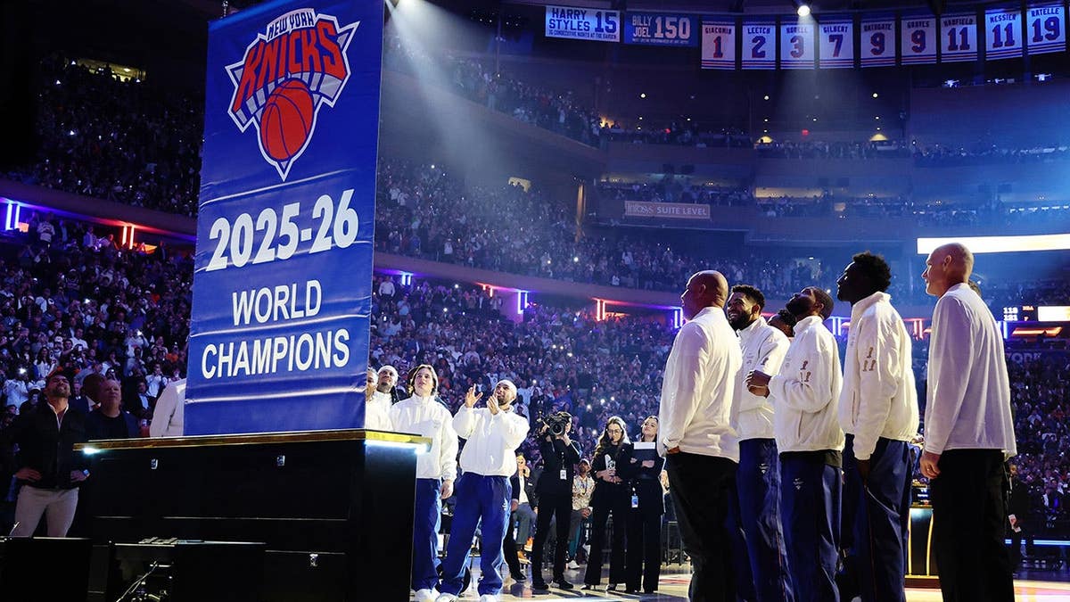 New York Knicks players look toward their new championship banner at Madison Square Garden.