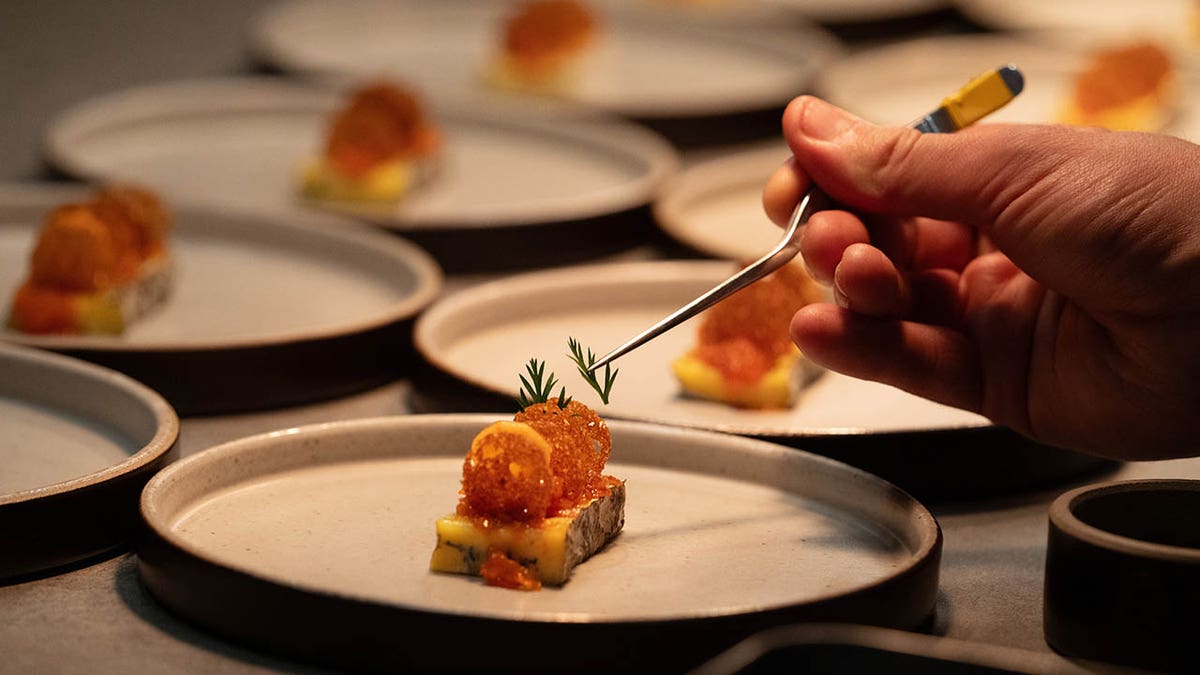 A photo of a dish being plated on Knife Edge