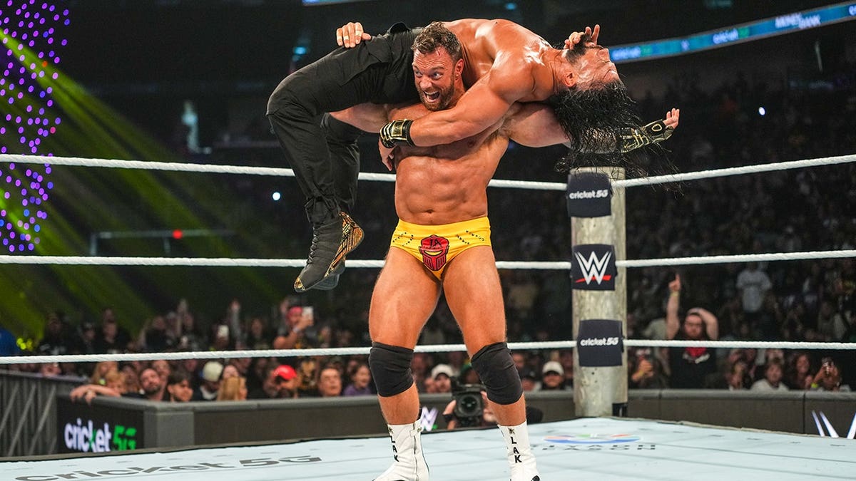 LA Knight in action against Roman Reigns during Money in the Bank wrestling match.