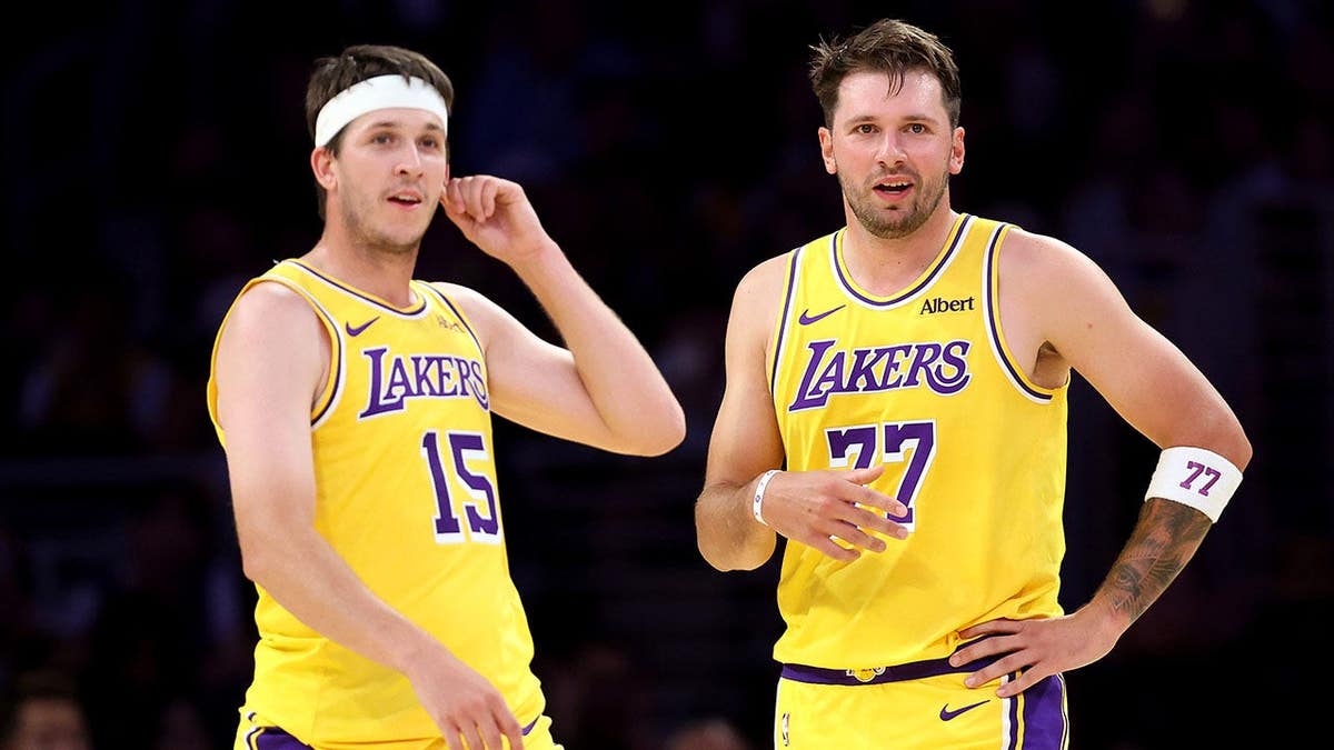Austin Reaves and Luka Doncic of the Los Angeles Lakers look on during a preseason game.