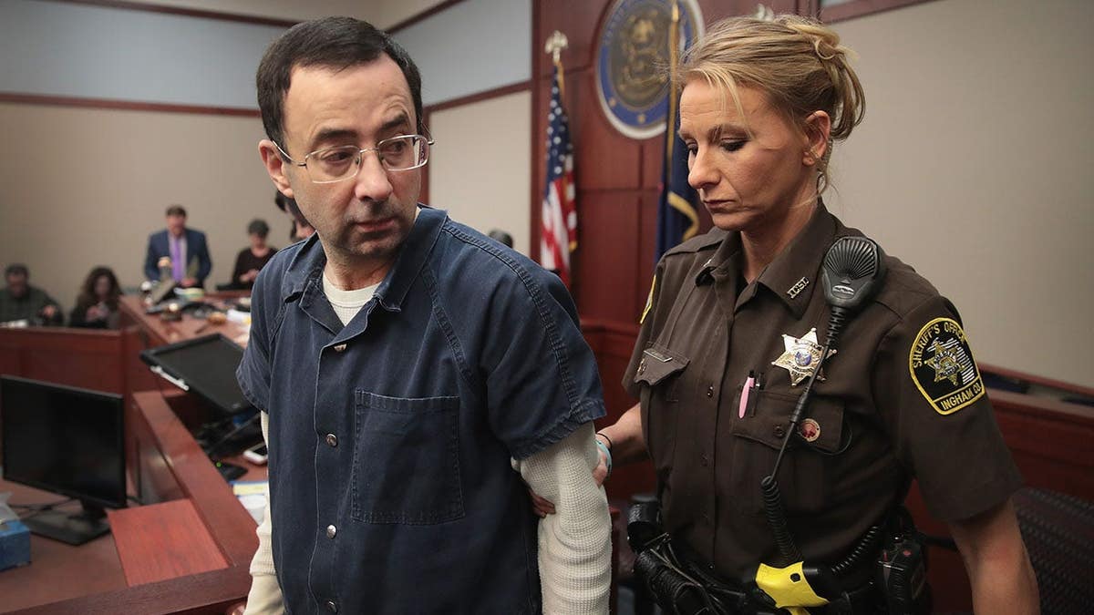 Larry Nassar appears in court listening to victim impact statements in Lansing, Mich.