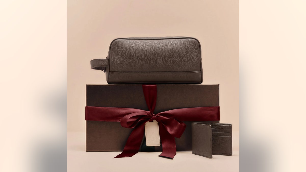 Gift a toiletries bag and leather wallet all in one.