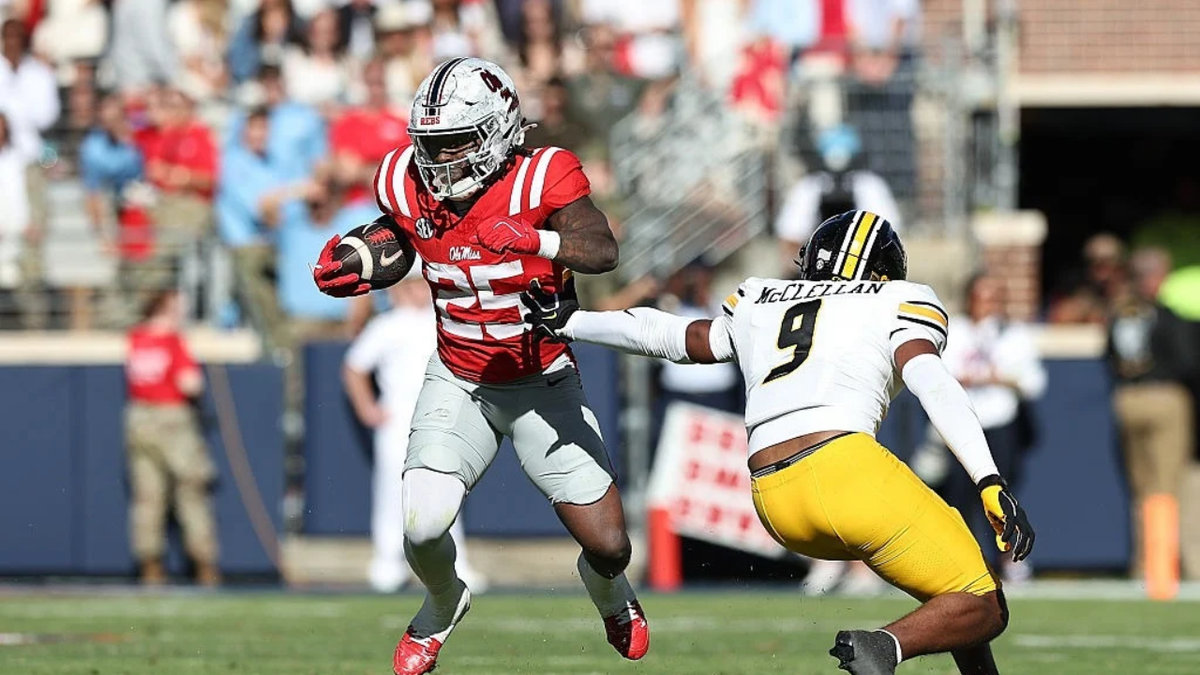 Makhi Frazier carries the ball as Dante McClellan defends during a football game.