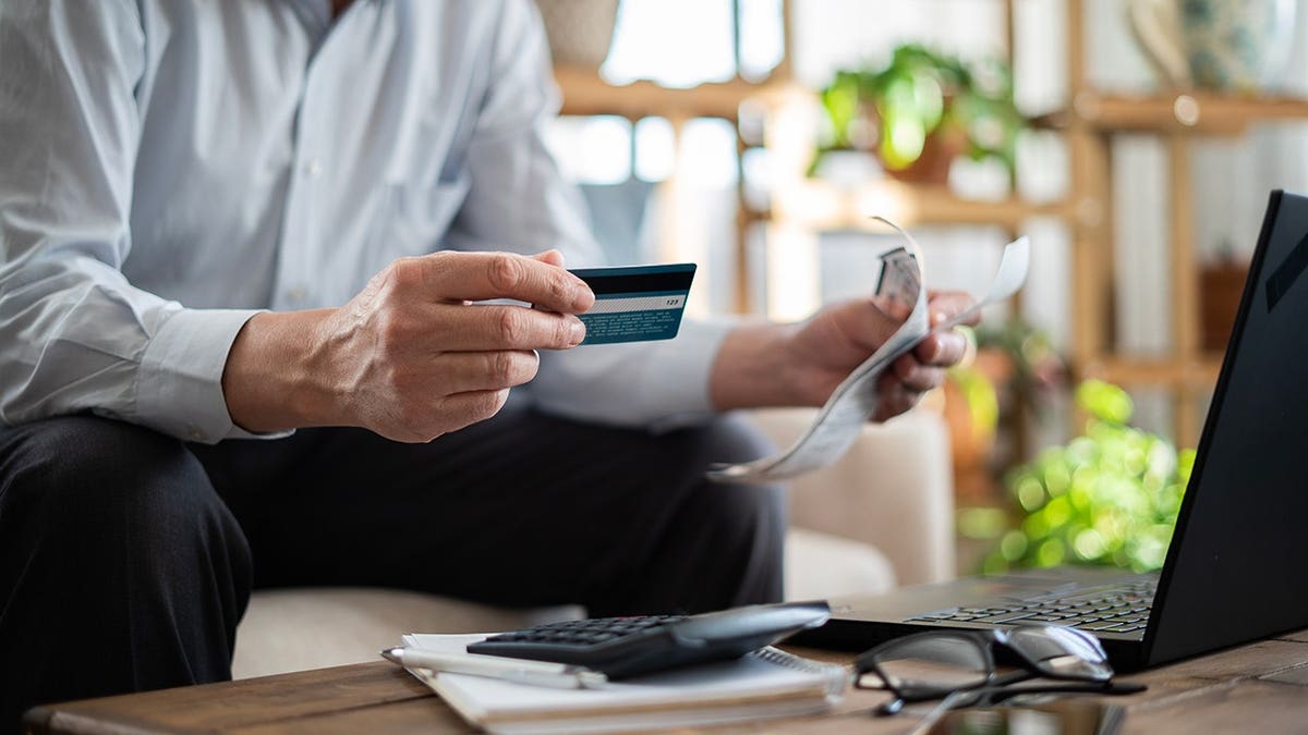 Senior man pays bills with a credit card