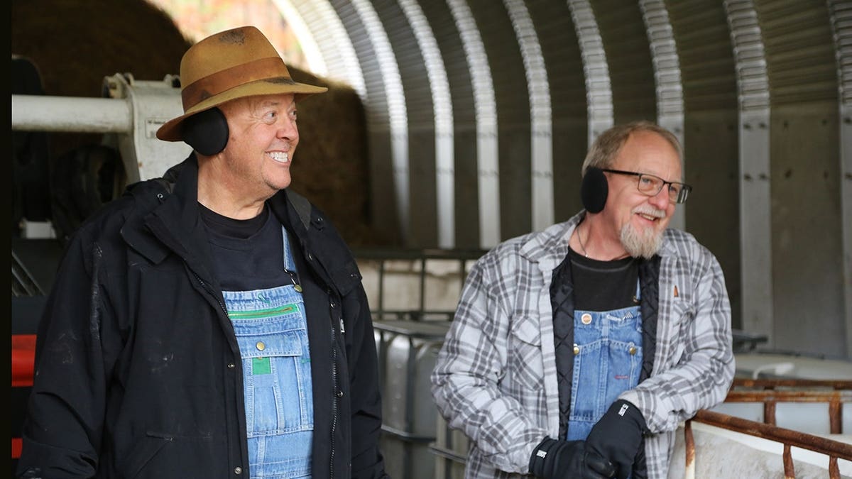 Mark Ramsey and Eric Digger Manes stand in a hay barn.