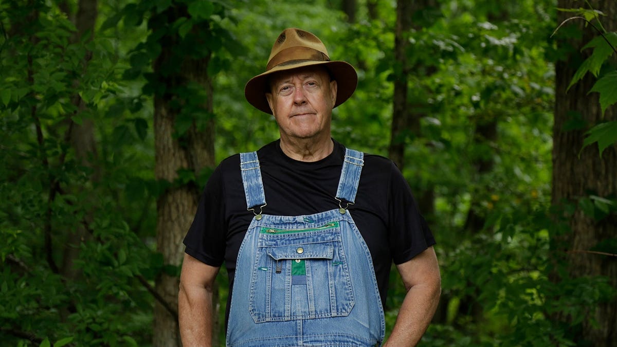 Mark Ramsey stands in the woods.