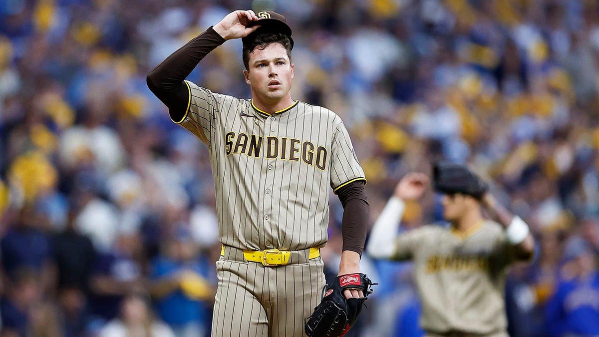 Mason Miller of the San Diego Padres adjusts his cap after walking Gary Sanchez of the Milwaukee Brewers.