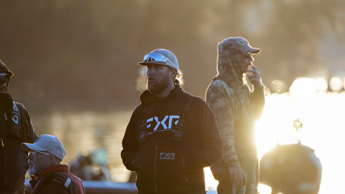 Angler Matt Anaya stands on his boat at sunrise