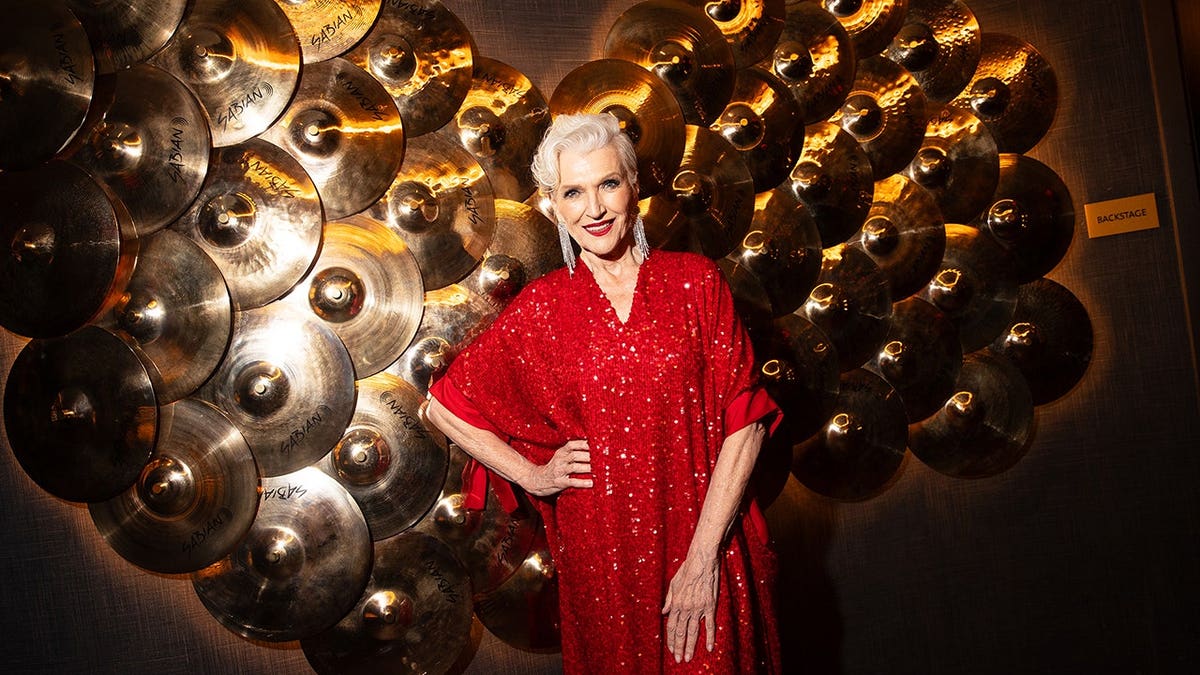 Maye Musk stands in a red dress at the Sports Illustrated Swim Issue Launch Party.