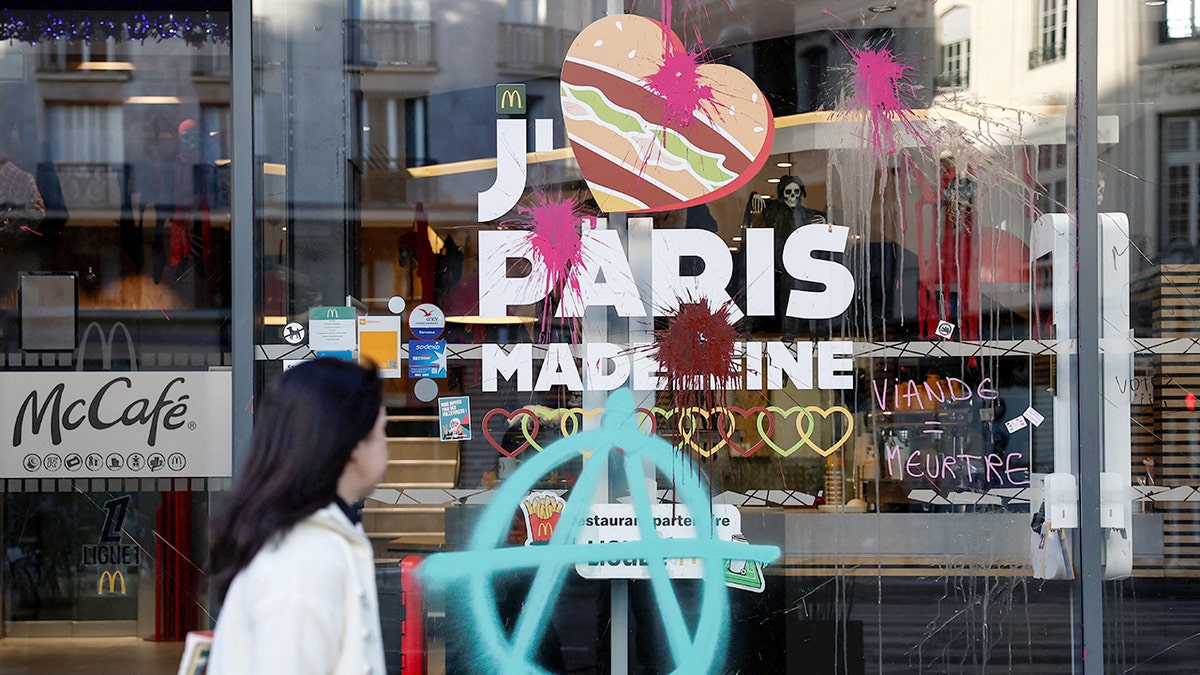 Graffiti is visible on the window of a McDonald's in Paris.