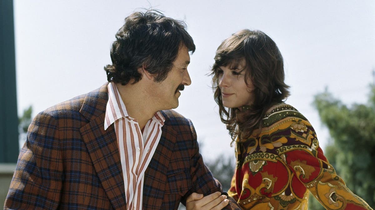 Rock Hudson as Commissioner Stewart McMillan and Susan Saint James as Sally McMillan stand together.