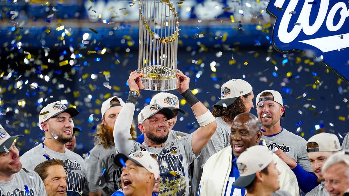 Miguel Rojas hoists the Commissioner's Trophy at Rogers Centre.