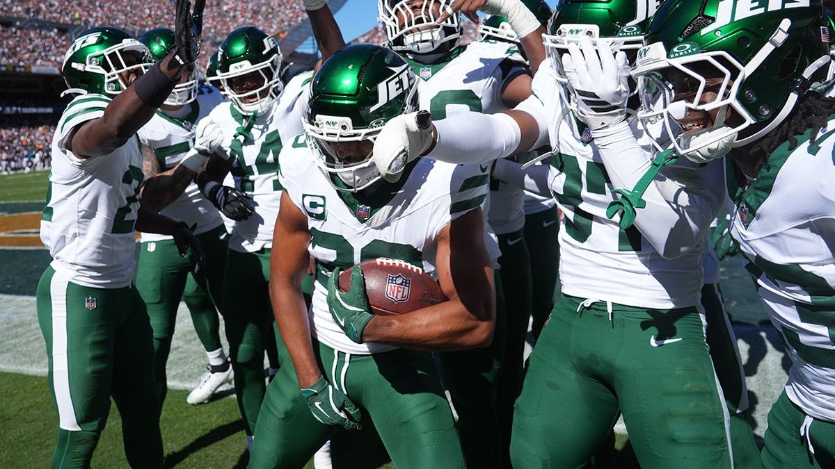 Minkah Fitzpatrick holds the ball and celebrates with teammates after an interception.