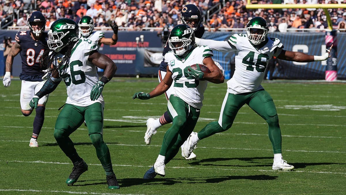 Minkah Fitzpatrick runs with the ball after intercepting a pass during an NFL game.