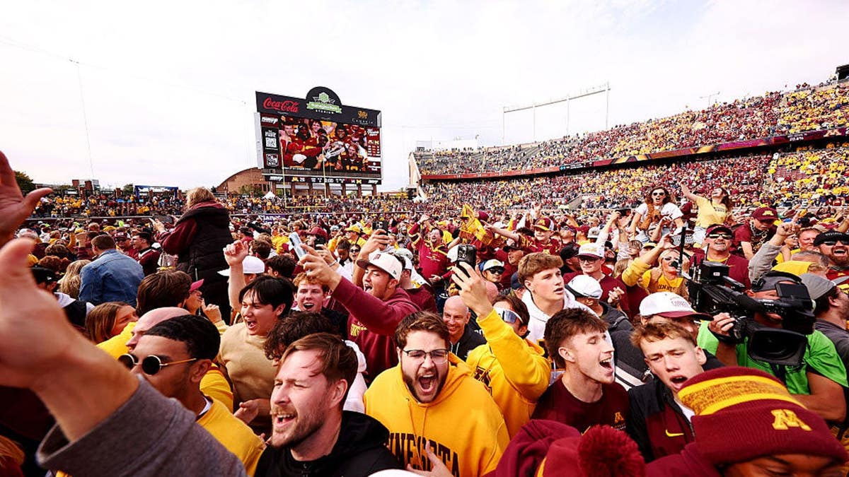 Fans storm the field at TCF Bank Stadium in Minneapolis.