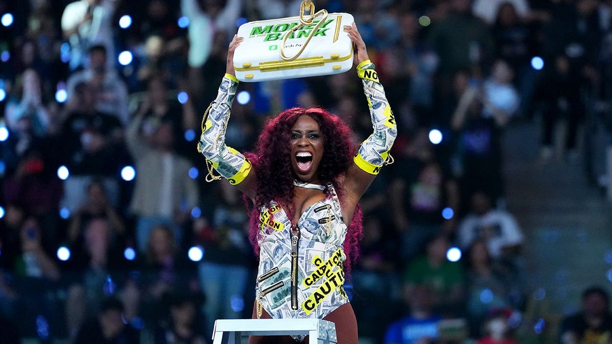 Naomi celebrates after winning the briefcase at WWE Money in the Bank.