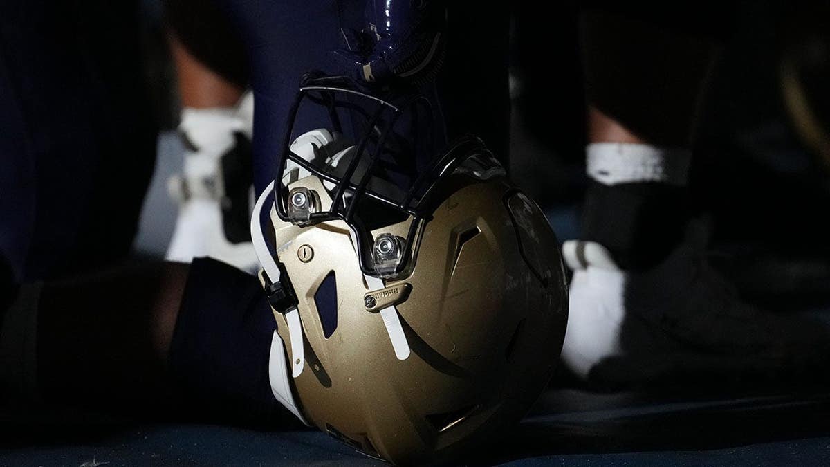 Navy Midshipmen player leans on his helmet during a timeout lightshow at Flagler Credit Union Stadium.
