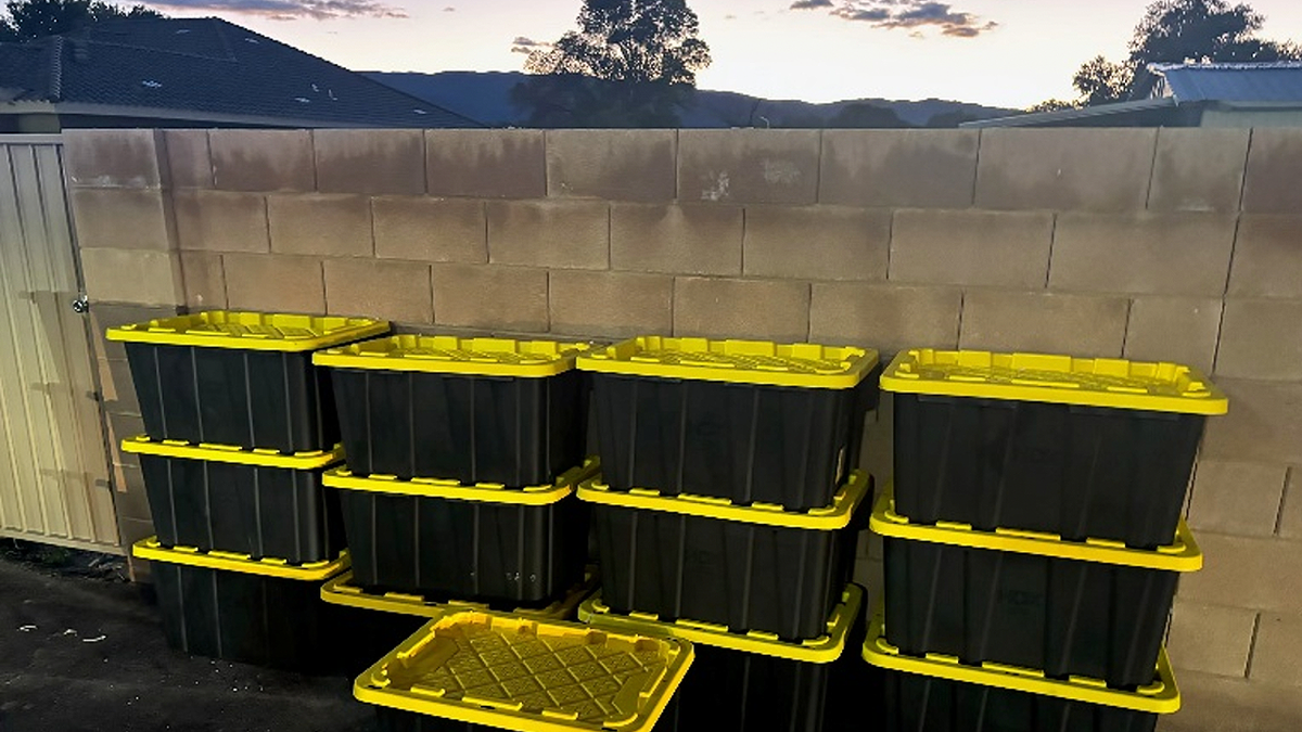 Black storage totes with yellow lids stacked outdoors following a Nevada drug seizure