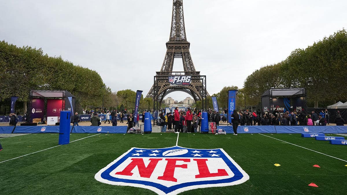 NFL shield logo on the field with the Eiffel Tower as a backdrop in Paris.