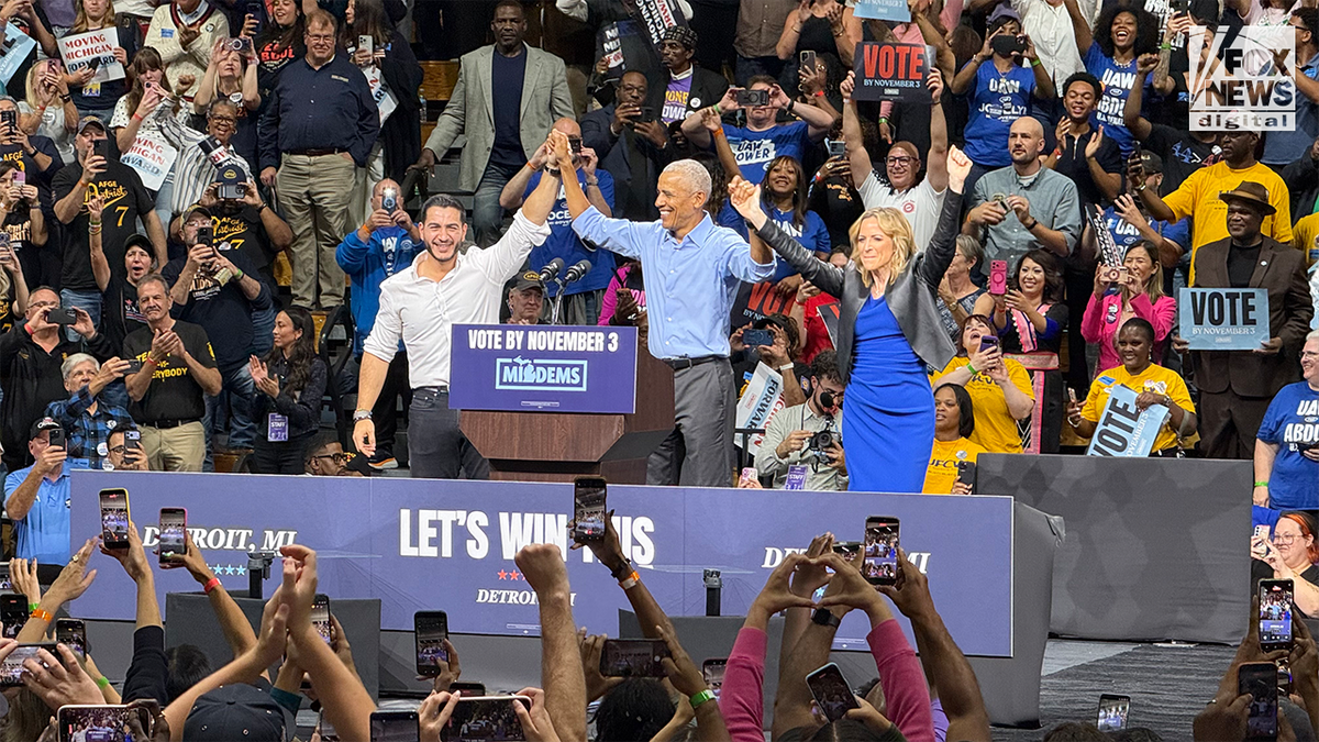 Former President Barack Obama speaks at a Democratic campaign rally in Detroit, Michigan, as supporters hold signs urging voters to cast their ballots by Nov. 3.