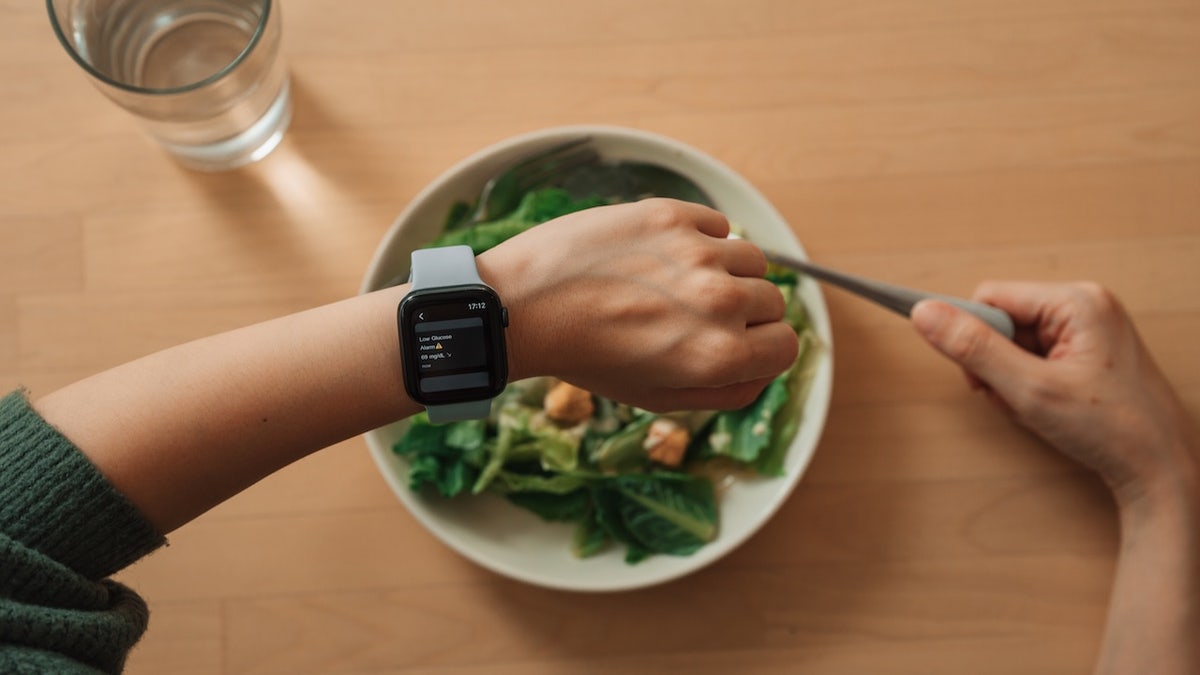 Person eating salad glucose monitor