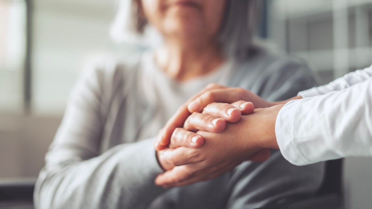 Holding older woman's hands