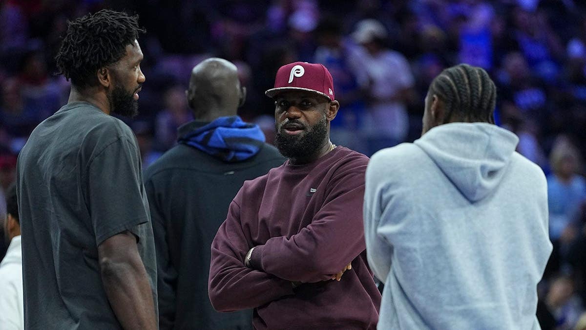 LeBron James talks to Joel Embiid and Tyrese Maxey during a preseason game in Philadelphia.