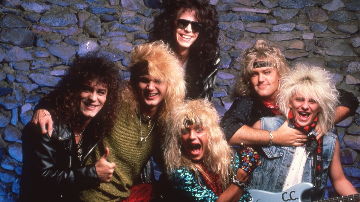 Poison band members Bret Michaels, Rikki Rockett, C.C. Deville and Bobby Dall pose at Joe Louis Arena.