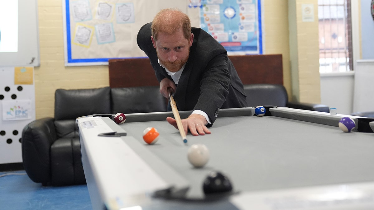 Prince Harry playing pool.