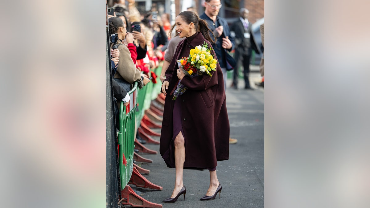 Meghan Markle walking with flowers in Nottingham.