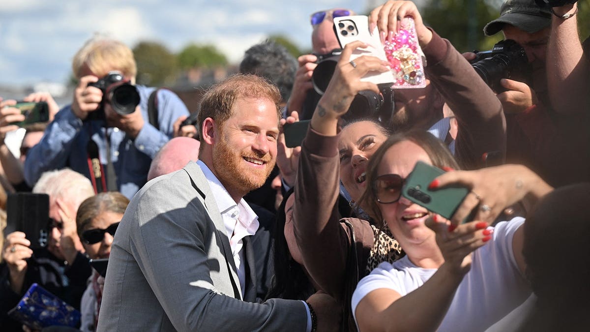 Prince Harry poses for a selfie with well-wishers in Nottingham.