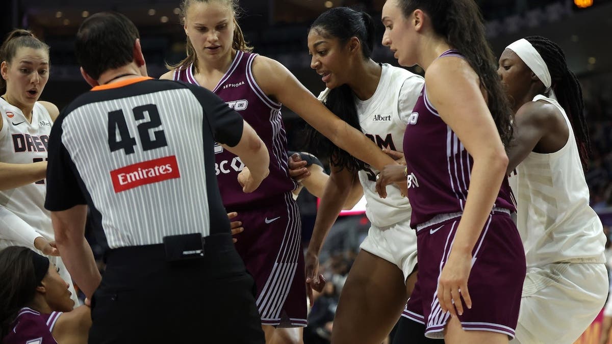 Angel Reese #5 looks down at Isabelle Harrison #21 after getting fouled during an WNBA game.