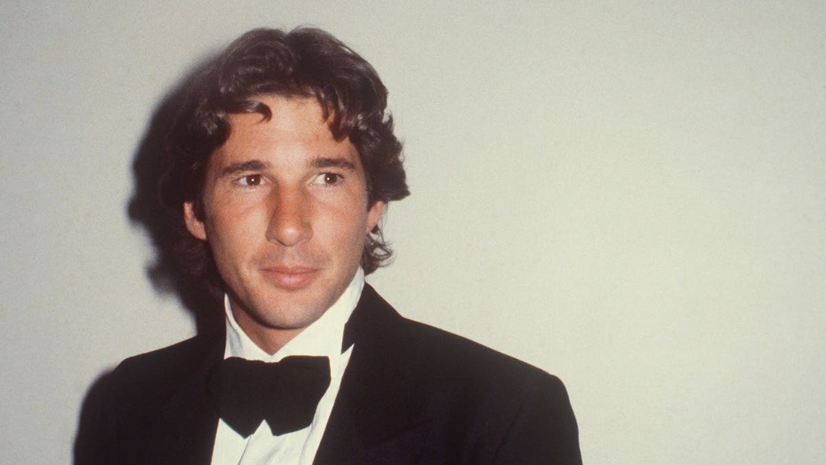 Richard Gere wears a tuxedo in a studio portrait.
