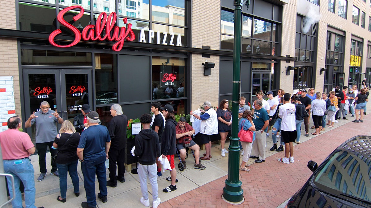 A crowd lines up down Summer Street waiting to enter Sally's Apizza in Stamford, Conn.