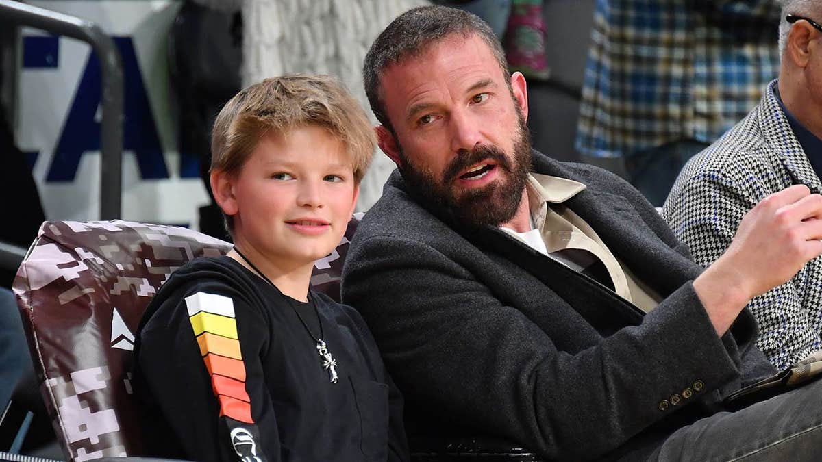 Ben Affleck y Samuel Garner Affleck sentados en un partido de baloncesto.