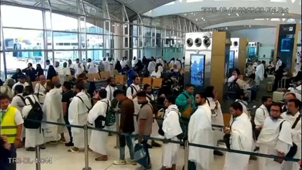 People stand in a queue inside King Khalid International Airport terminal.