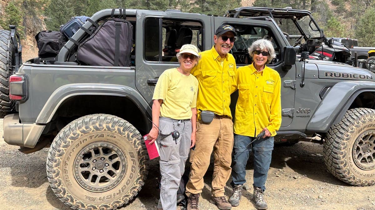 Search and rescue teams standing in front of a car.