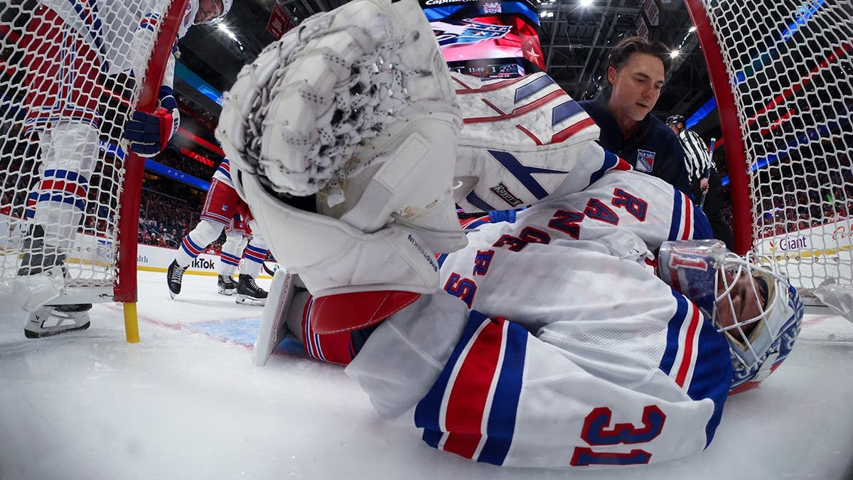 Igor Shesterkin receives attention after an injury during a game.