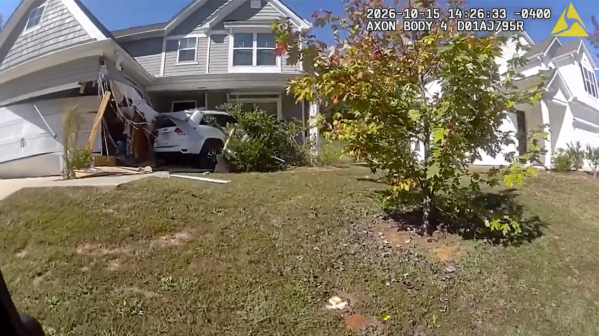 White SUV sits against a Simpsonville home with extensive damage around the garage