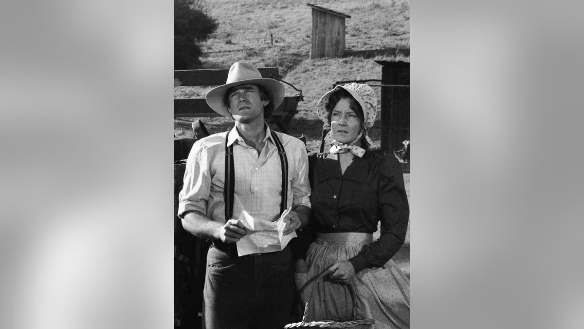 Stan Ivar as John Carter and Pamela Roylance as Sarah Reed Carter stand together in a scene from Little House on the Prairie.