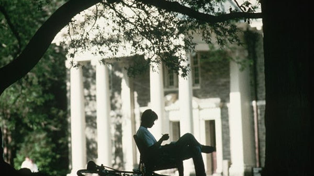 Student stands silhouetted against Georgian antebellum architecture at Haverford College.