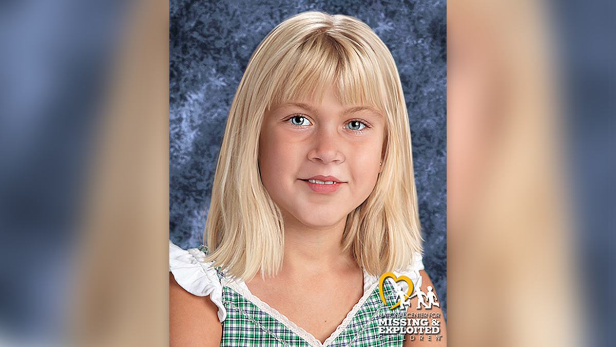 Summer Wells in an age-progressed photo, with blonde hair, bangs, and blue eyes, wearing a white and green plaid dress